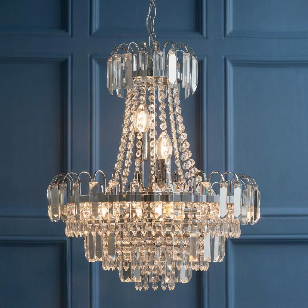 Amadis clear faceted glass and chrome pendant ceiling light against a blue paneled wall.
