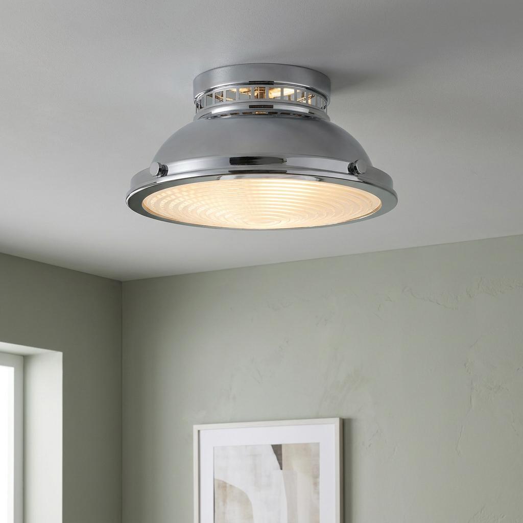 Polished chrome flush mount ceiling light with a circular ribbed glass lens, installed in a modern interior.