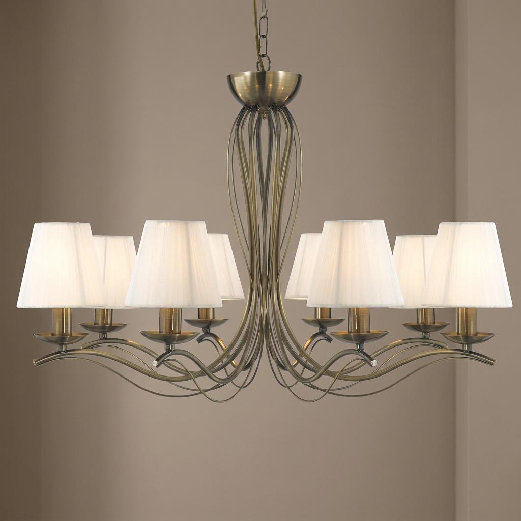 8-light antique brass chandelier with elegant sweeping wire arms and cream pleated fabric shades.