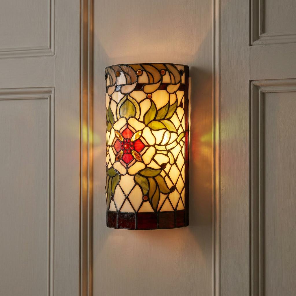 Illuminated Tiffany-style floral wall sconce with red and green stained glass mounted on a white paneled wall.