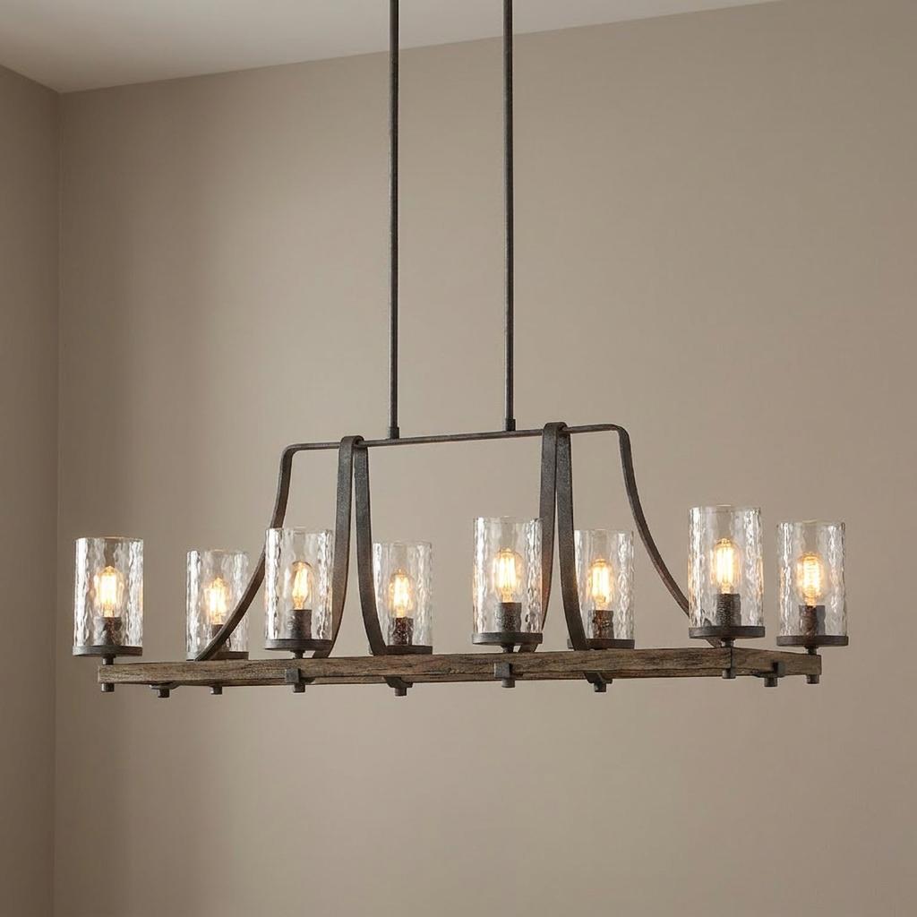 Angelo 9 light metal and wood linear chandelier with cylindrical glass shades hanging in a neutral room.
