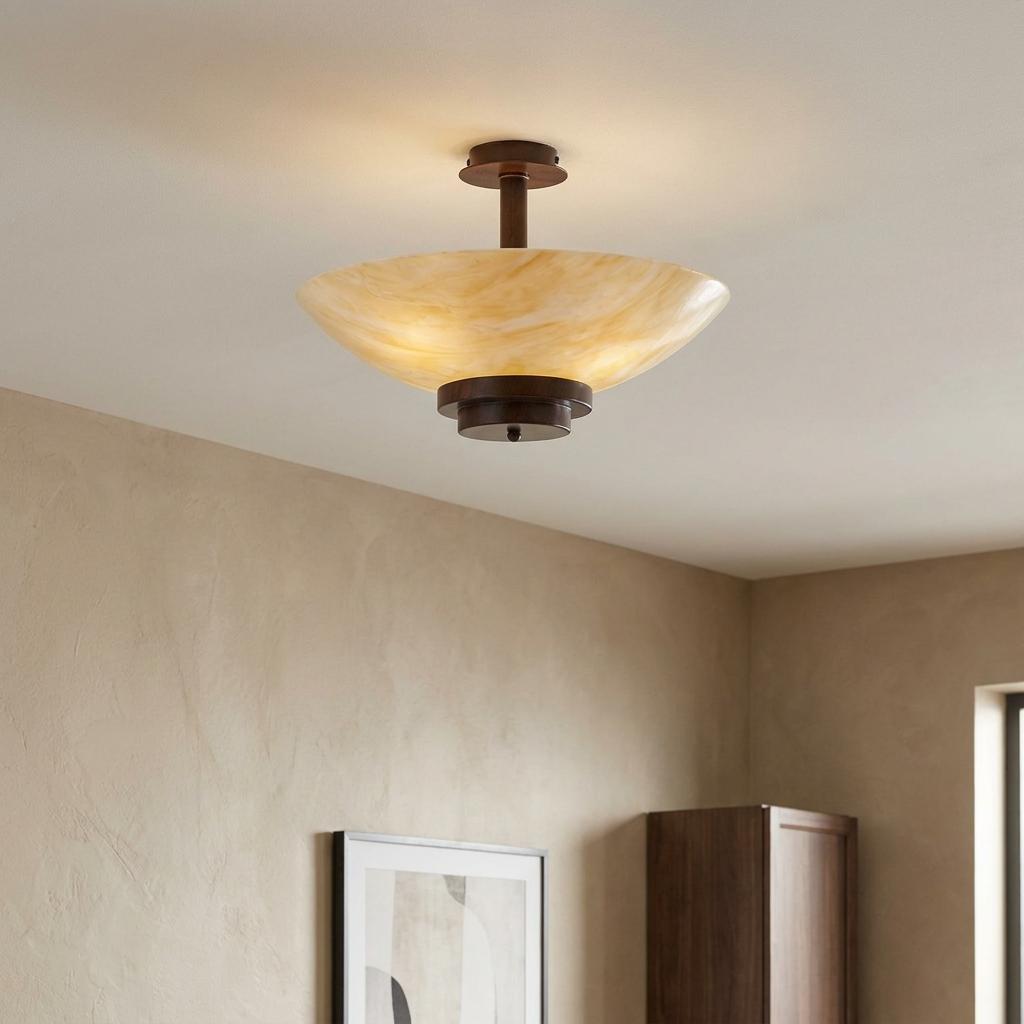 Art Deco semi-flush ceiling light with an antique bronze finish and amber marbled glass bowl in a neutral room.