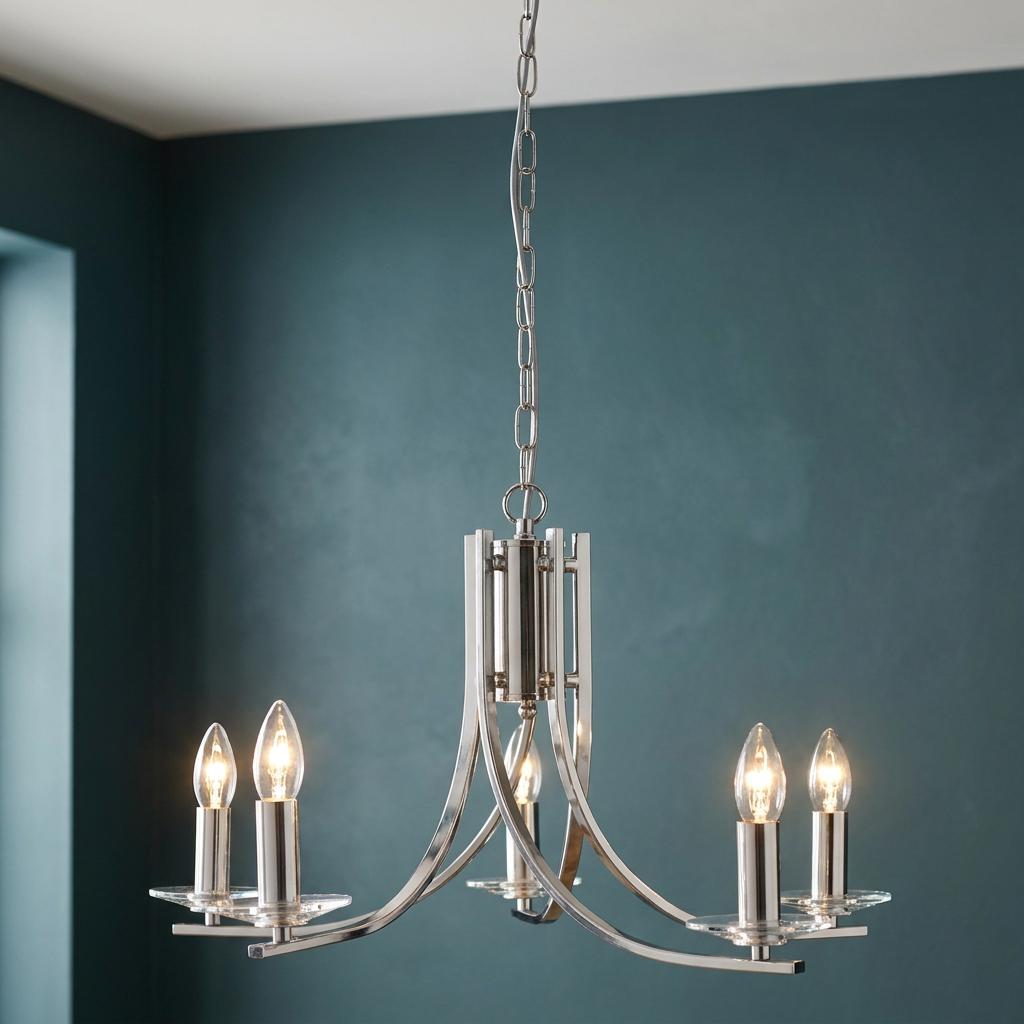 Ascona 5-light satin silver chandelier with glass sconces and lit candle bulbs against a teal wall.