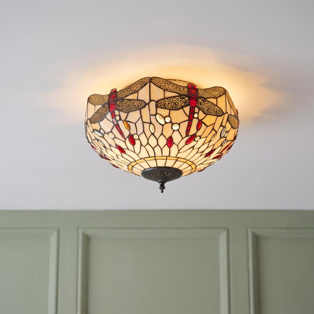 Beige Tiffany-style flush ceiling light with red dragonflies and glass beads glowing against a white ceiling.