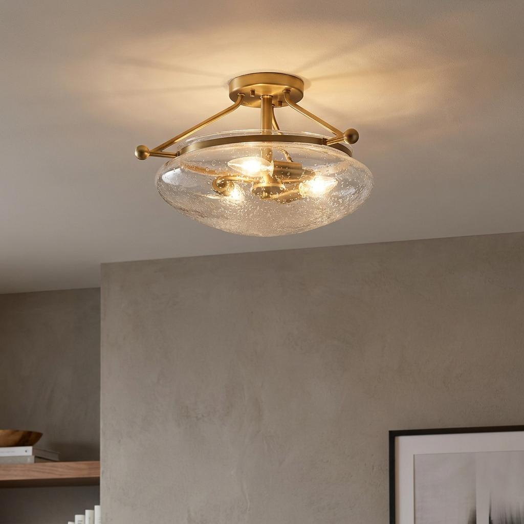 Belle 3 light brass semi-flush ceiling light with a seeded glass shade mounted on a white ceiling.