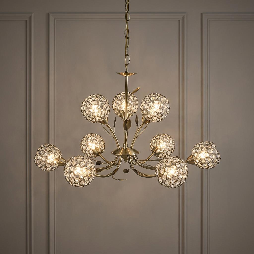 Nine-light antique brass chandelier with sparkling crystal globes hanging against a neutral paneled wall.