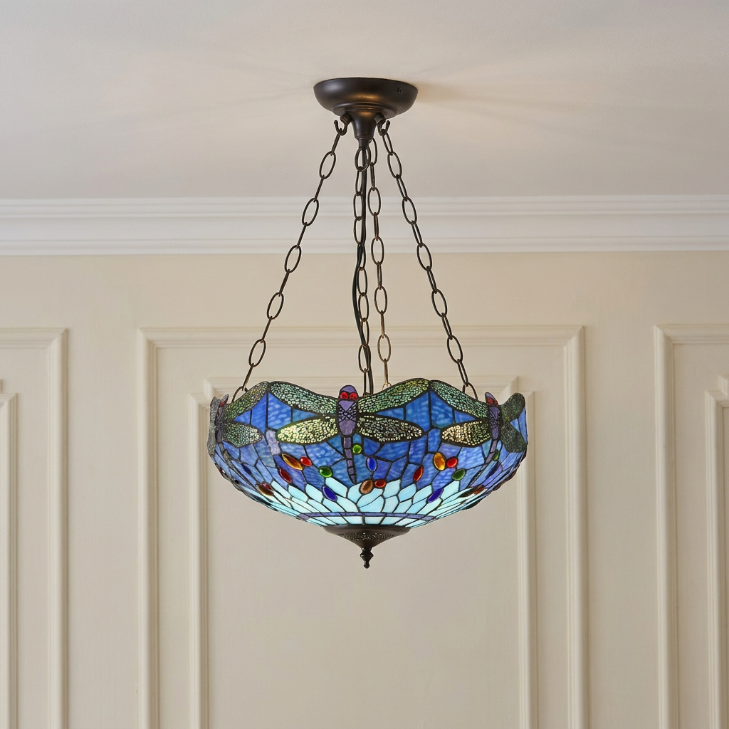 Inverted Tiffany ceiling light with a blue dragonfly stained glass shade hanging against a cream paneled wall.
