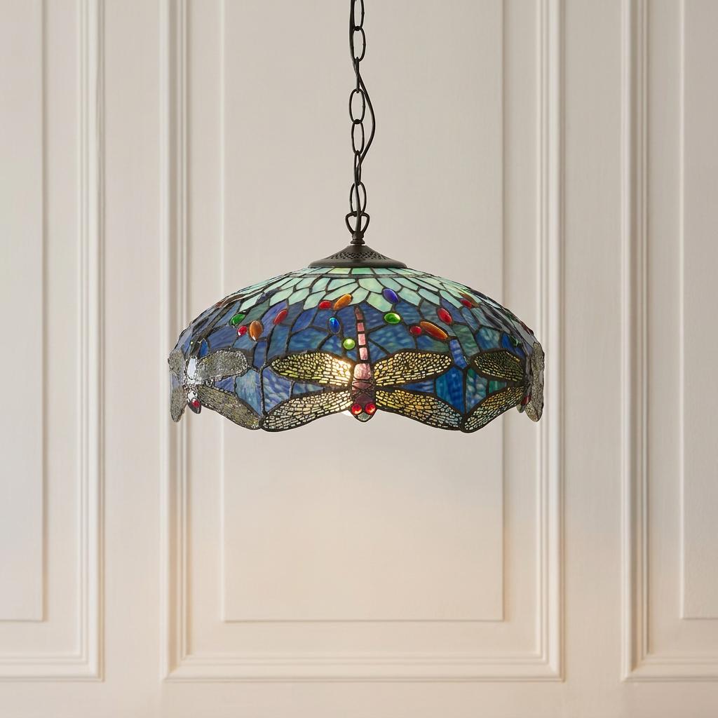 Blue dragonfly Tiffany ceiling light with stained glass and colorful beads, hanging against a paneled wall.
