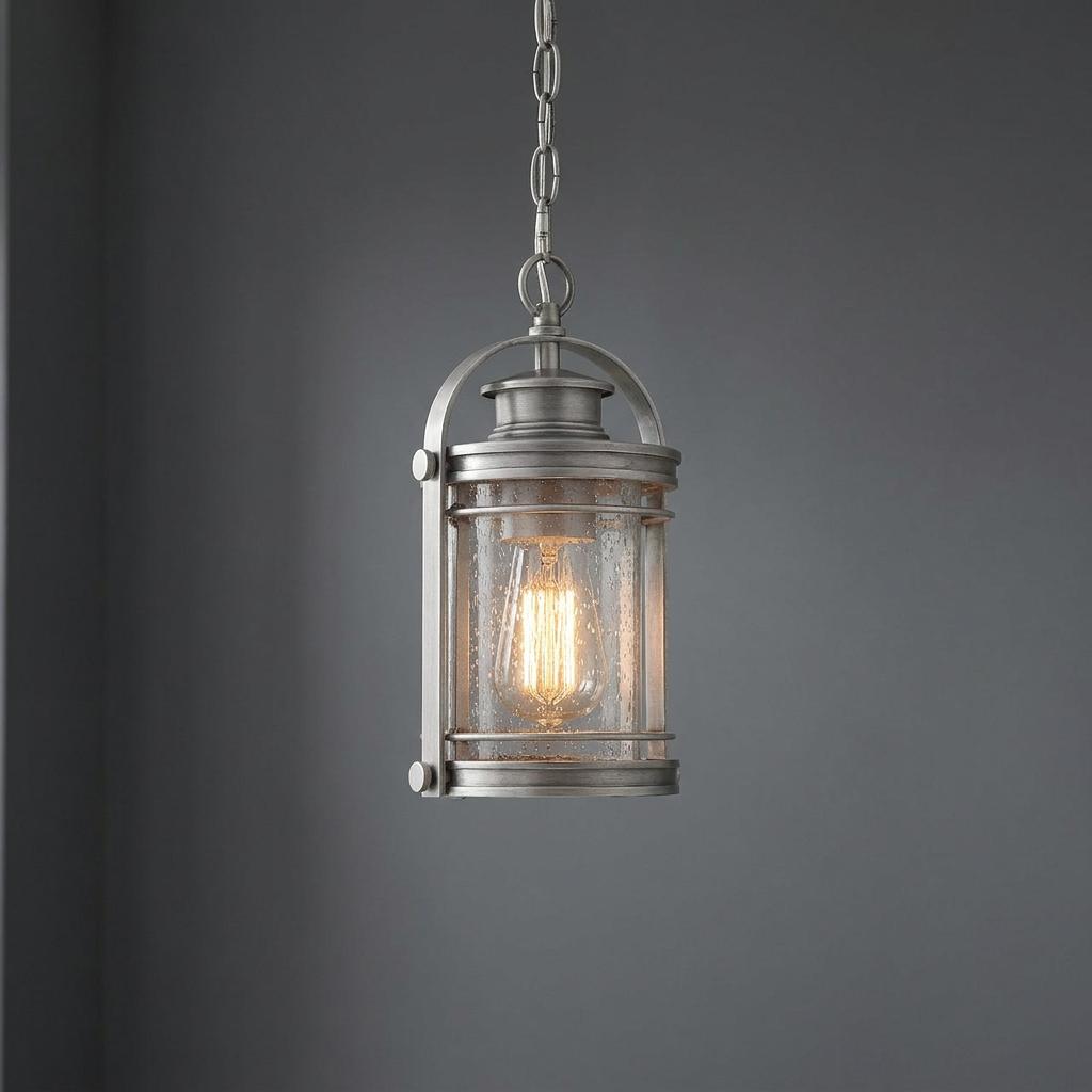 Booker small outdoor chain lantern in a pewter finish with seeded glass and a warm glowing Edison bulb.