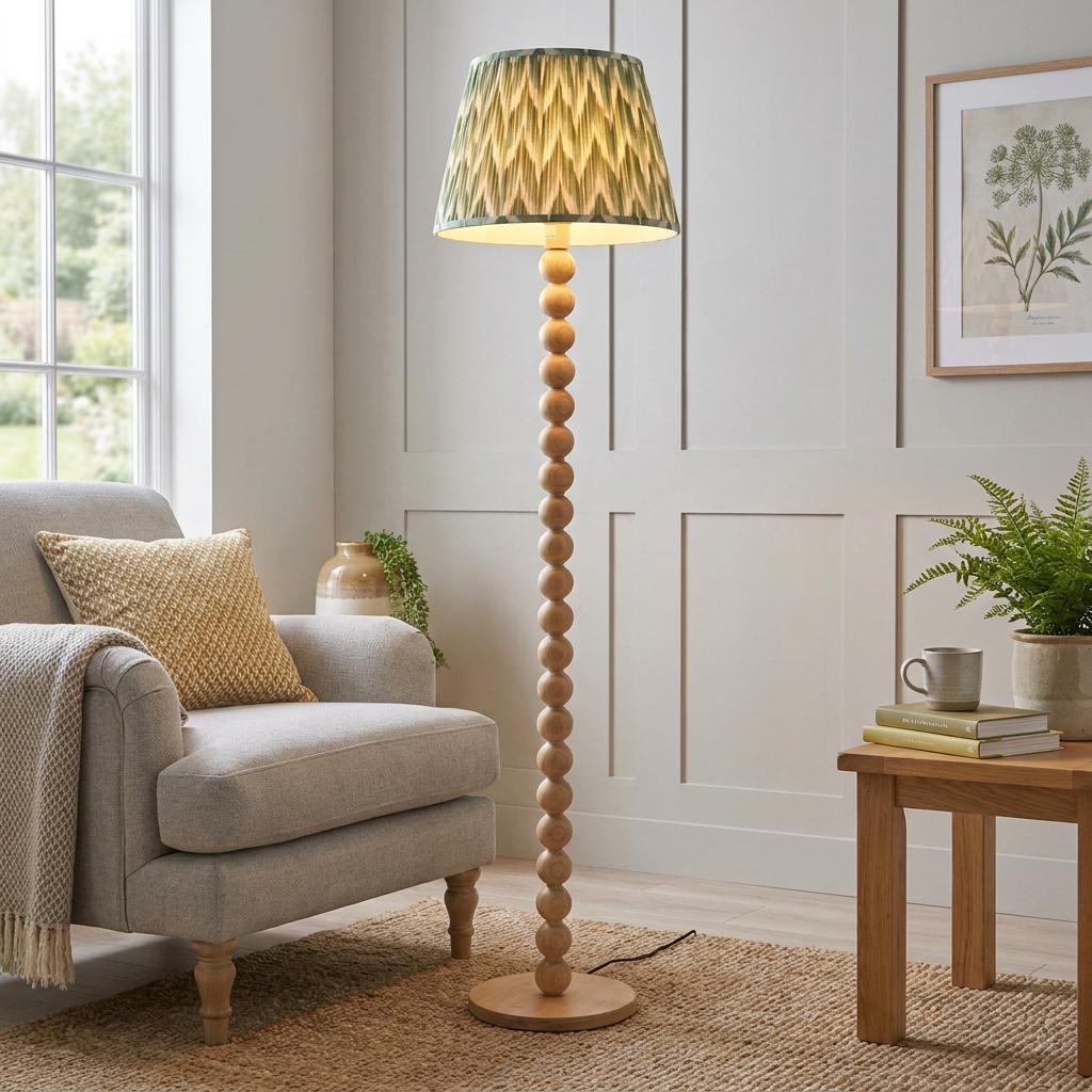 Cane bamboo floor lamp with a green zigzag patterned shade in a cozy living room setting with an armchair.