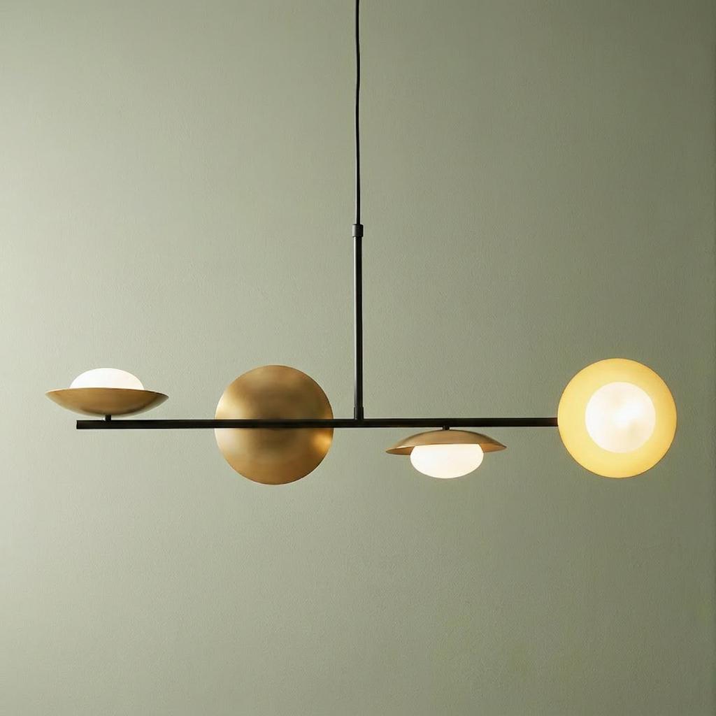 Modern linear ceiling pendant with four spherical lights and gold-toned metallic discs against a pale green wall.