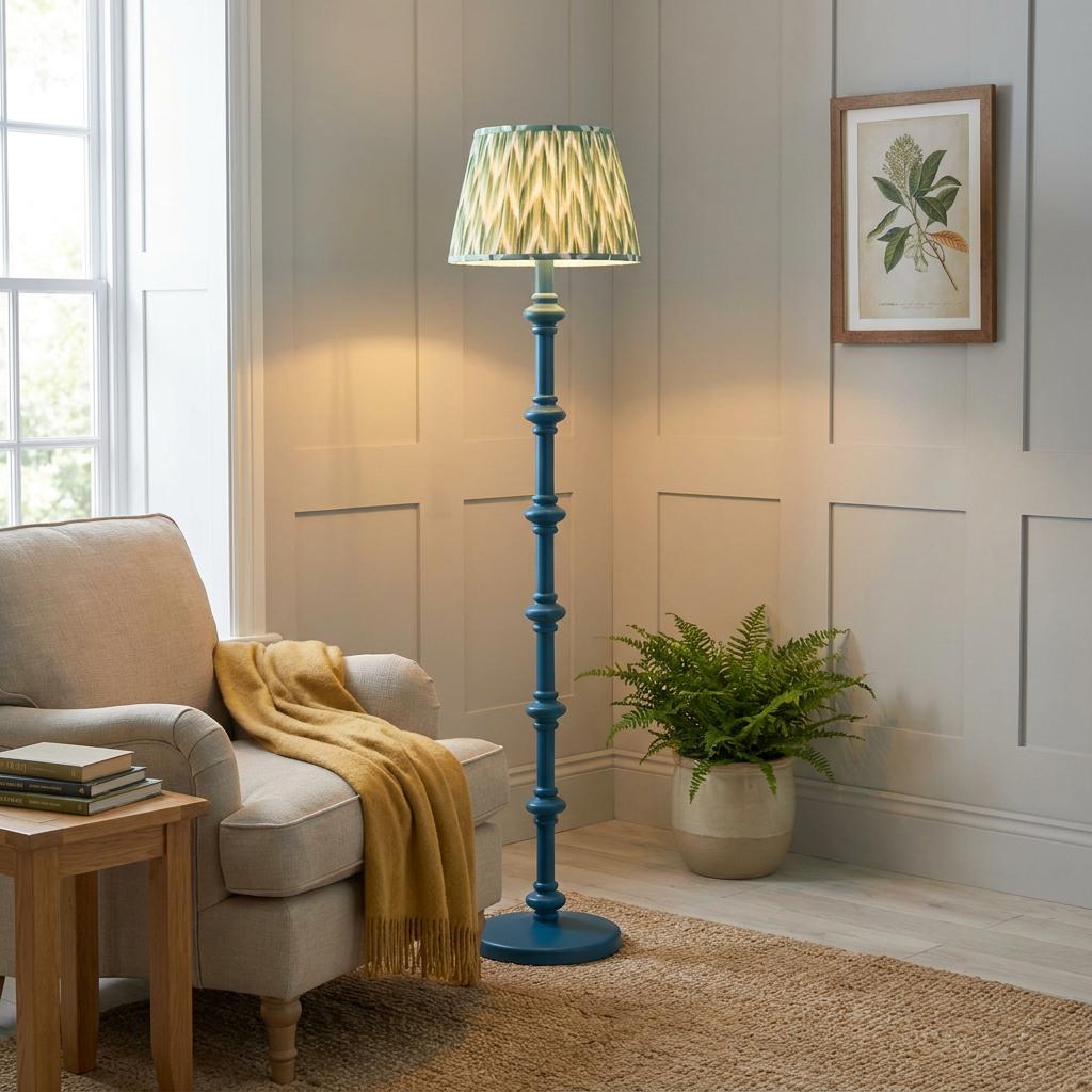 Blue floor lamp with a green zigzag shade stands in a cozy living room corner next to a beige armchair.