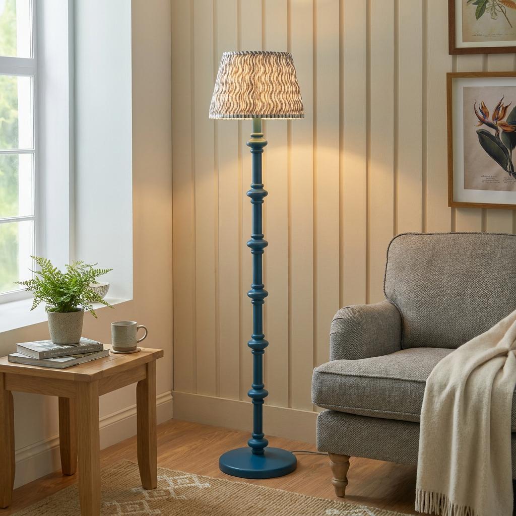 Blue bobbin floor lamp with a ripple grey shade in a cozy living room next to an armchair.