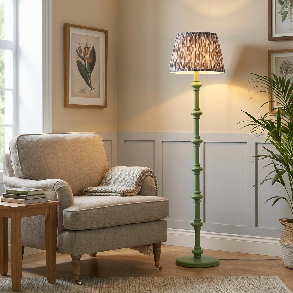 Carnaby green floor lamp with an ikat pearl grey shade beside a grey armchair in a living room.