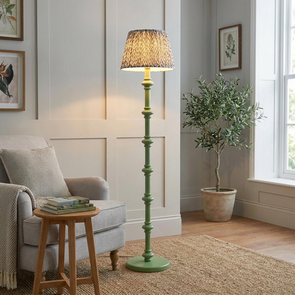 Green spindle floor lamp with a grey leaf-patterned shade in a cozy living room interior.