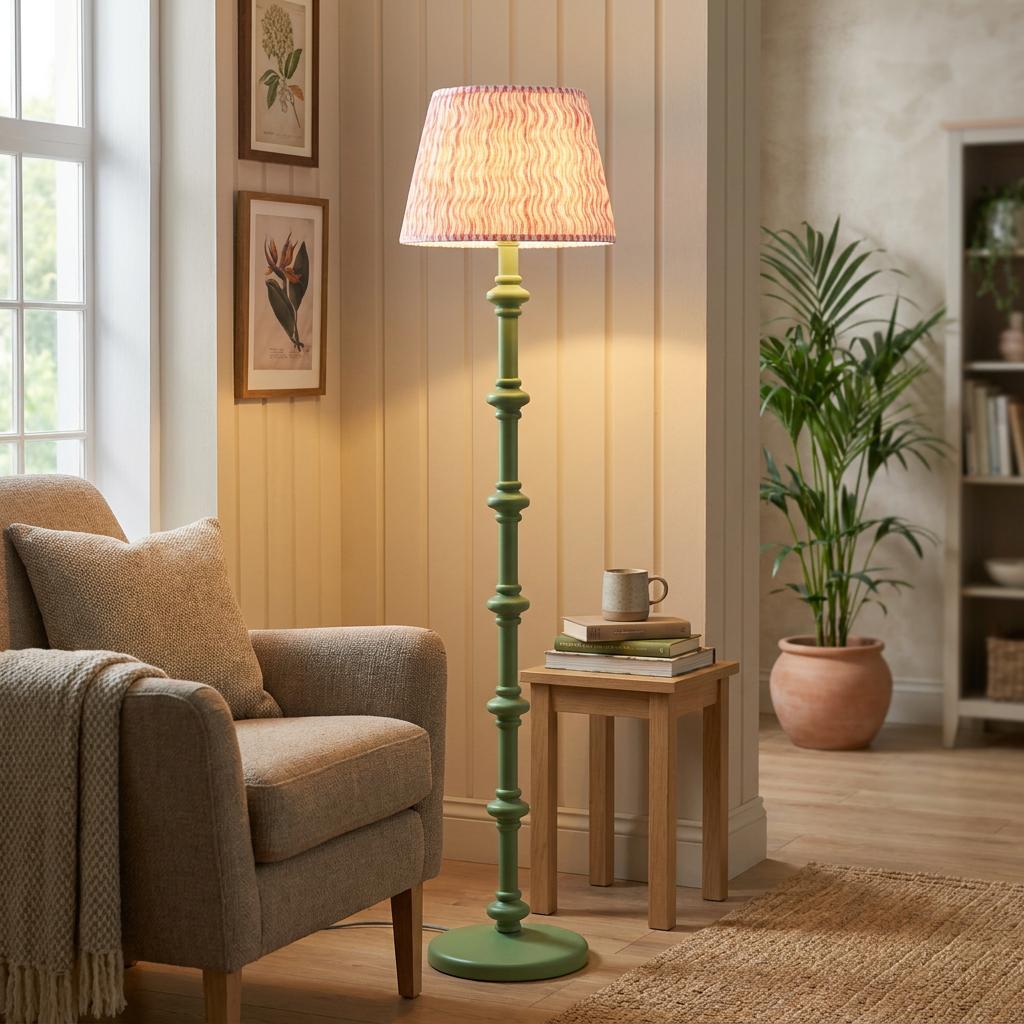 Green wooden floor lamp with a coral pink ripple shade in a cozy living room interior.
