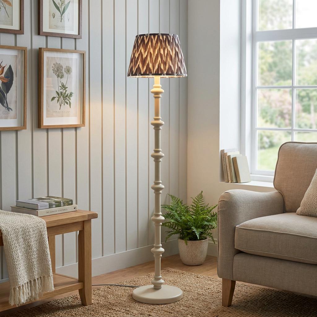 Carnaby white floor lamp with a zigzag pattern shade in a living room next to a chair.