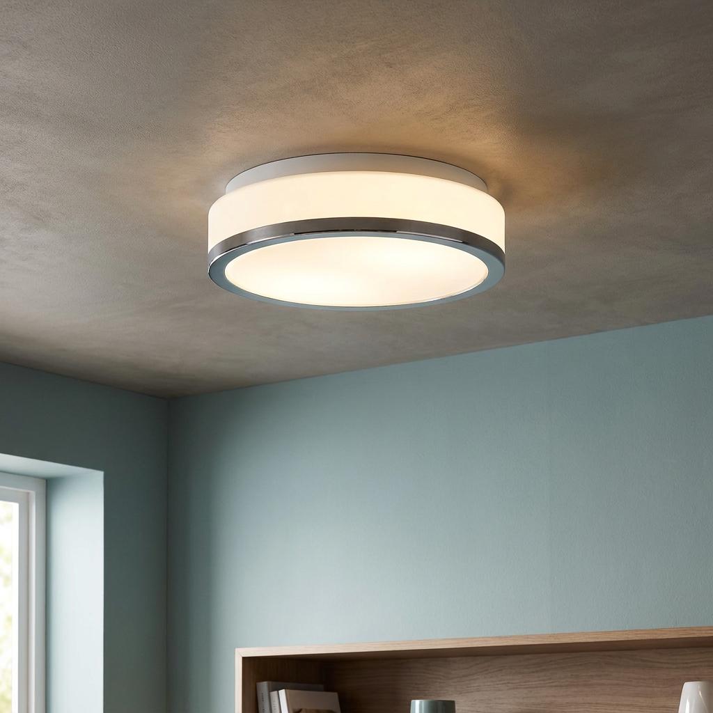 Round flush-mount ceiling light with white glass shade and chrome trim on a textured ceiling.