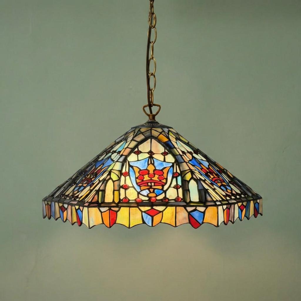 Ornate Cheltenham Tiffany pendant light with stained glass shade featuring a crown motif, hanging from a brass chain.
