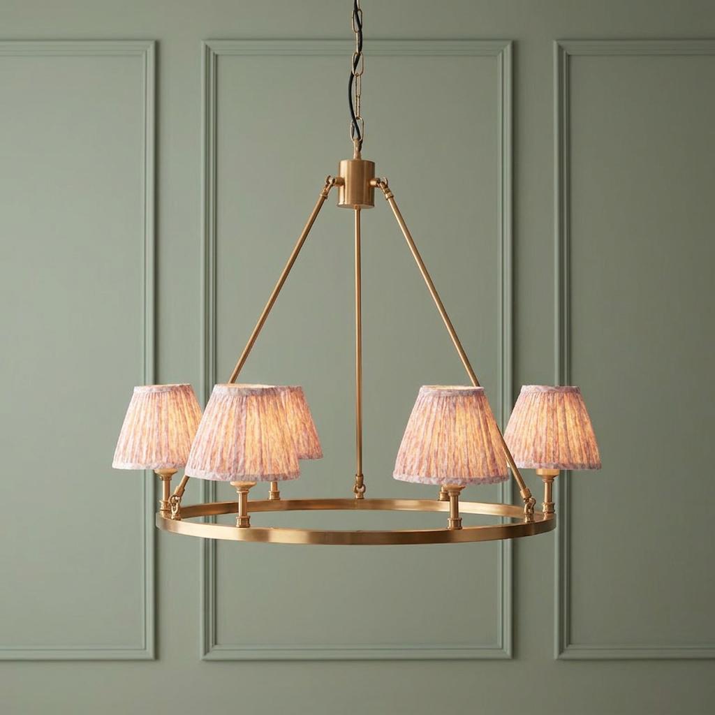 Chester large brass hoop pendant light featuring six pleated peachy leaf fabric shades against a sage green paneled wall.