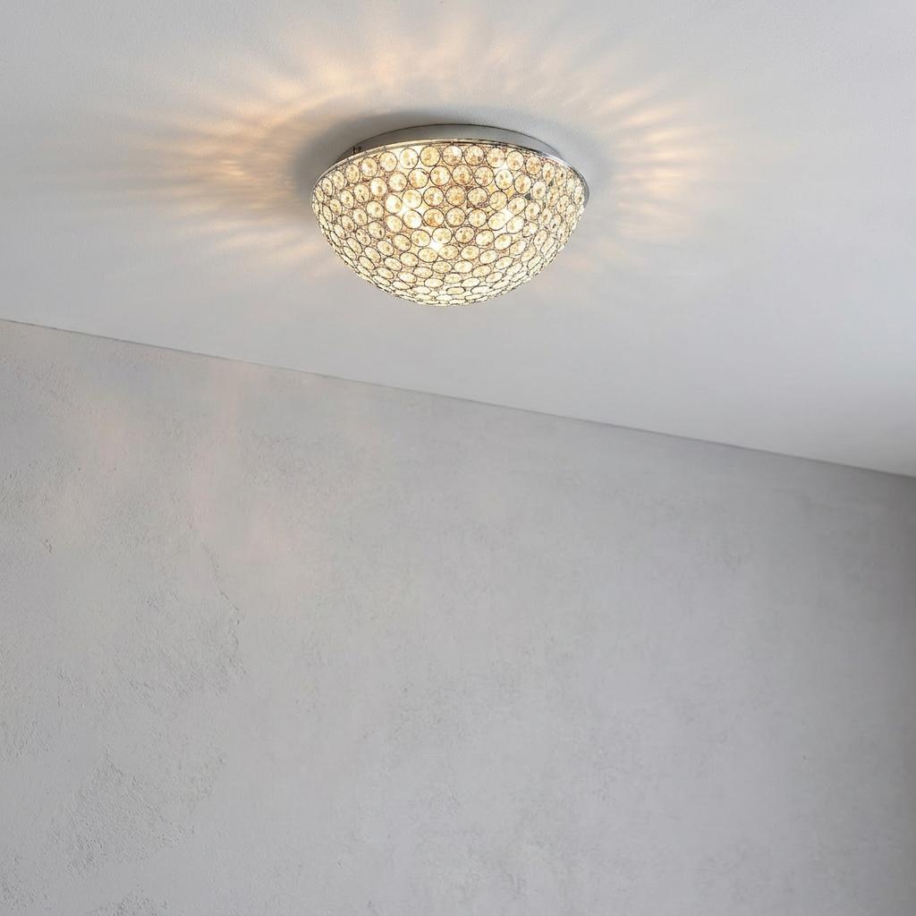 Chryla clear crystal and chrome flush dome ceiling light casting decorative patterns on a white ceiling.