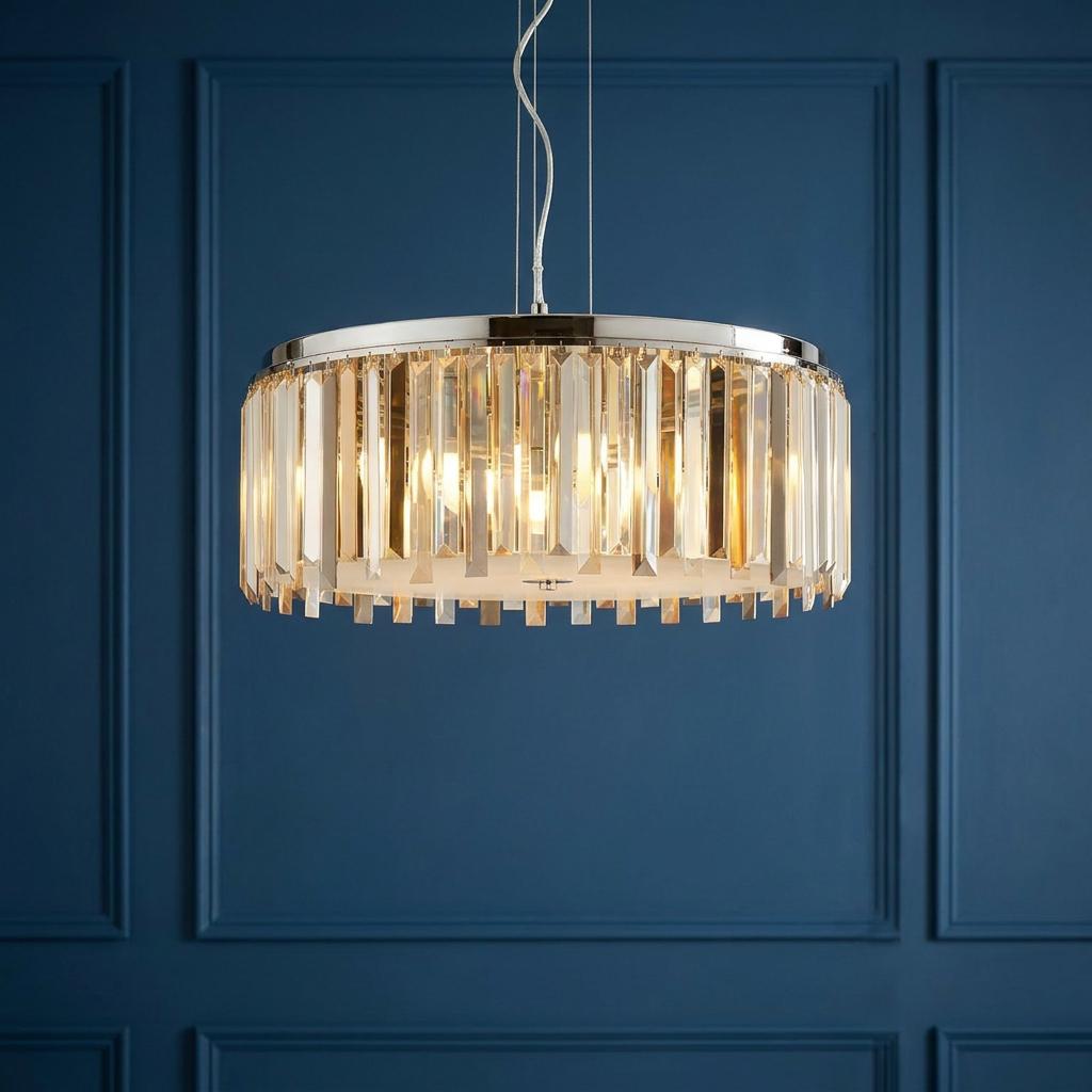 Clarissa 5 light chrome drum pendant with crystal prism drops hanging against a dark blue paneled wall.
