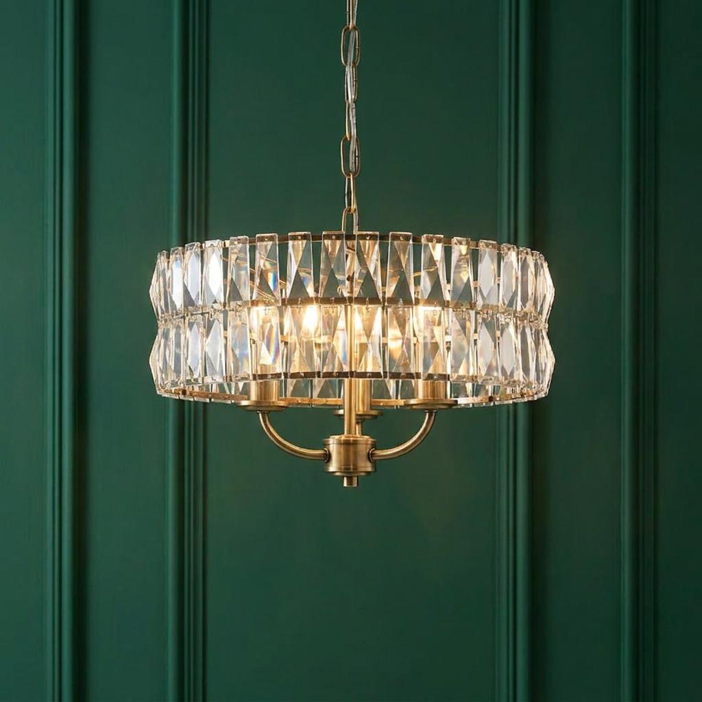 Clifton 3 Light Brass & Clear Cut Glass Pendant with tiered crystal elements against a green wood-paneled wall.
