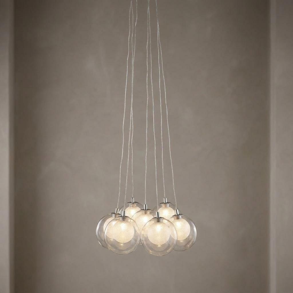 Cluster of seven glass and crystal LED globe pendant lights hanging against a neutral textured wall.