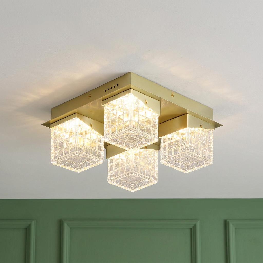 Satin brass flush ceiling light featuring four glowing textured glass cuboid shades on a square mount.