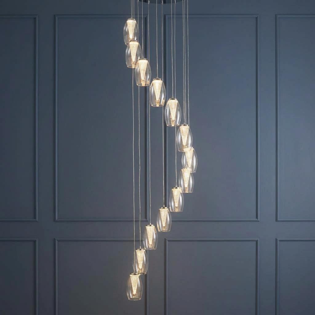 Cyclone 12-light LED multi-drop pendant with spiral glass shades against a dark blue paneled wall.