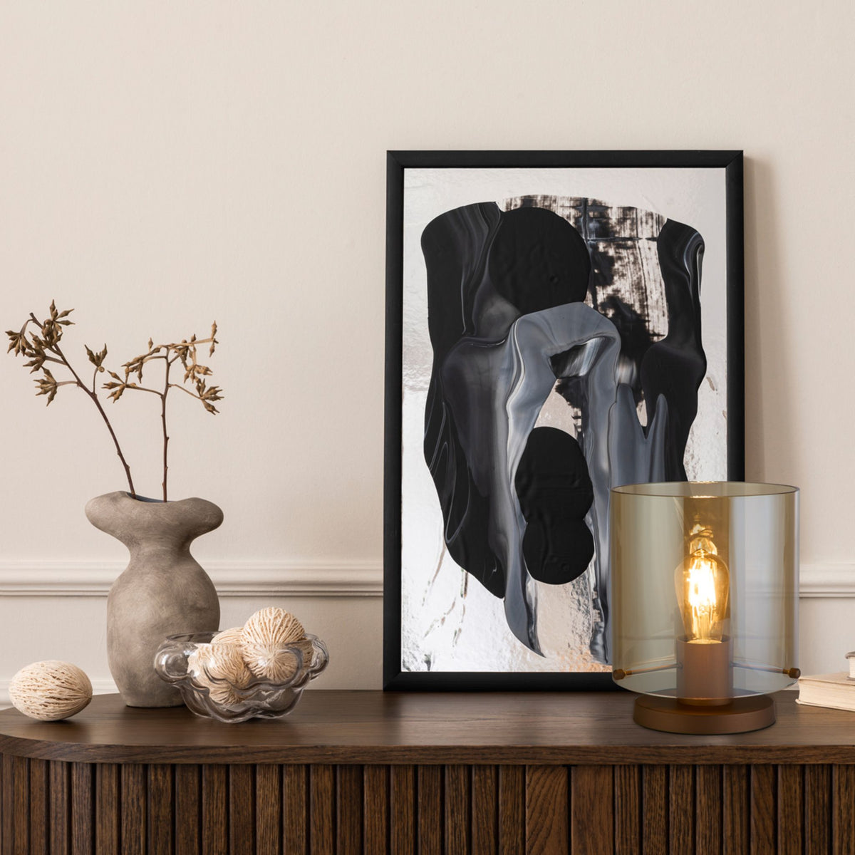 Sweden amber glass table lamp on a walnut sideboard with abstract art and stone vase