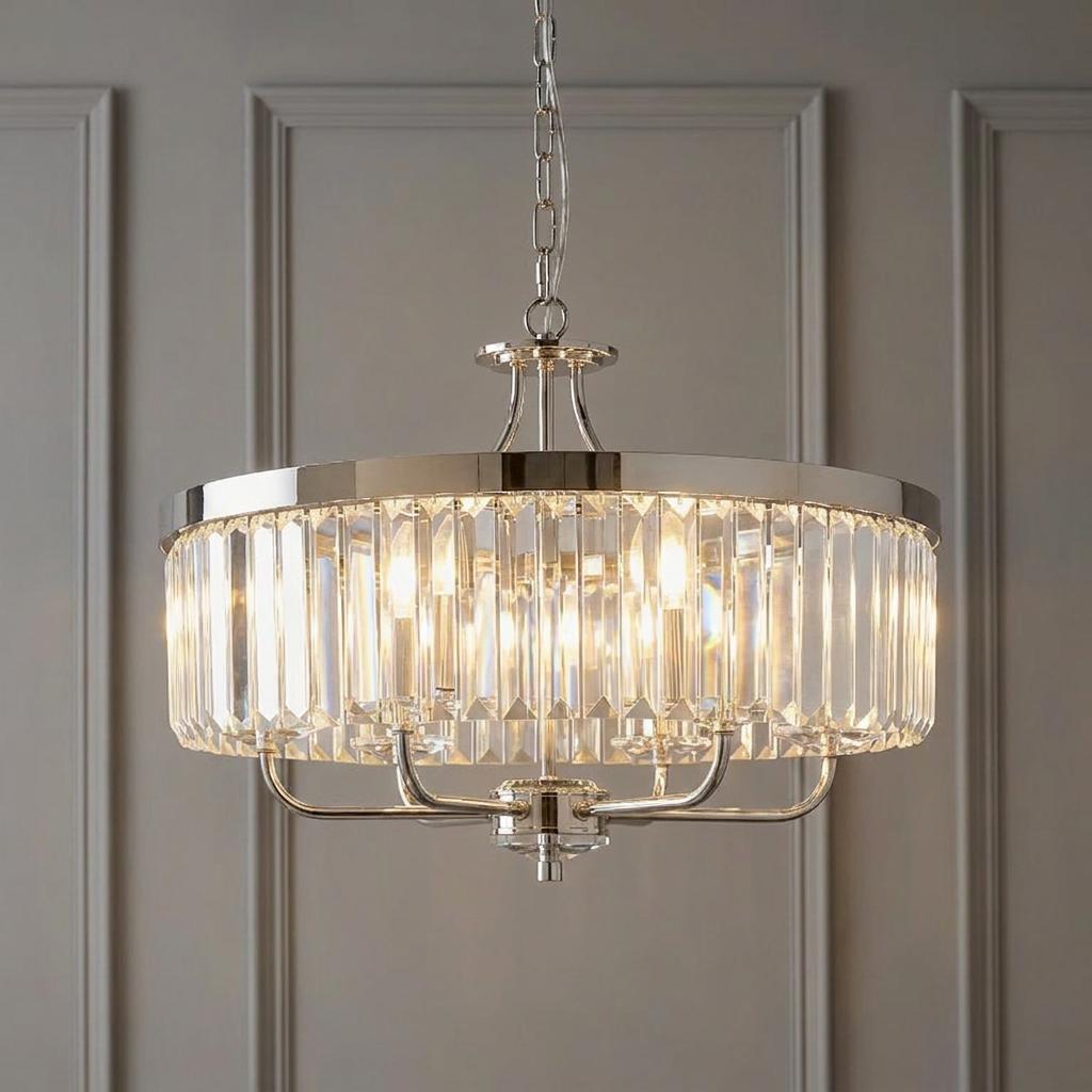 Ealing Round 6 Light Chrome and Clear Cut Glass Pendant with glowing bulbs against a grey paneled wall.