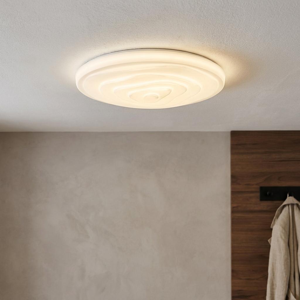 Round Eglo Battistona LED white ceiling flush light with a ripple effect design mounted on a light gray ceiling.