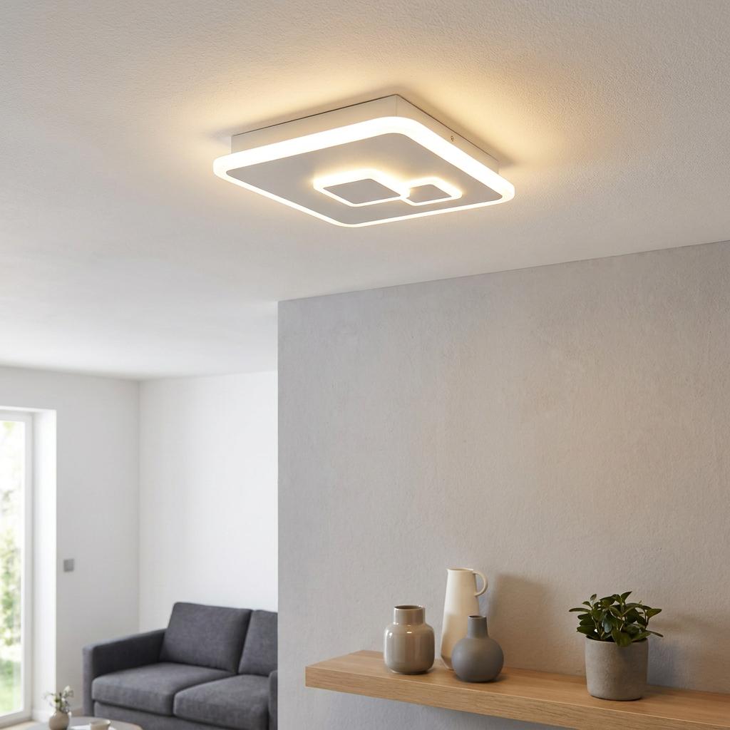 White square LED flush ceiling light with glowing geometric inner squares illuminating a modern interior.