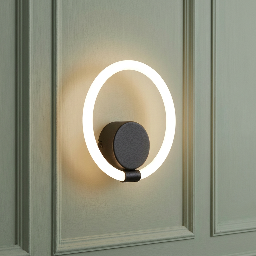 Circular black LED wall light with a glowing white ring mounted on a light green paneled wall.