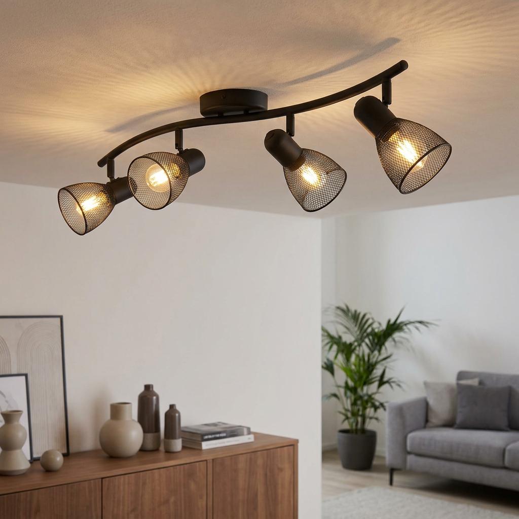 Black four-light bar spotlight with mesh shades illuminates a modern living room setting.