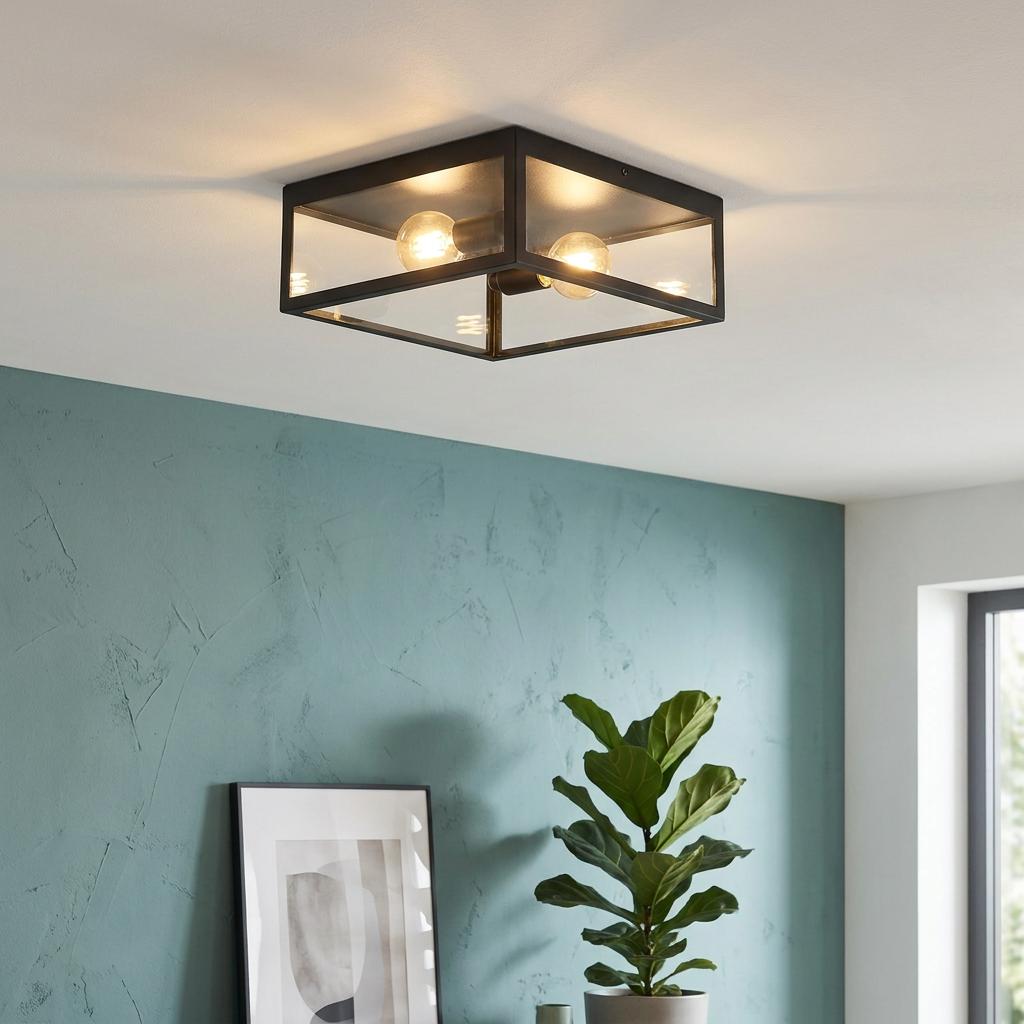 Modern square black framed flush ceiling light with two bulbs on a white ceiling above a textured teal wall.