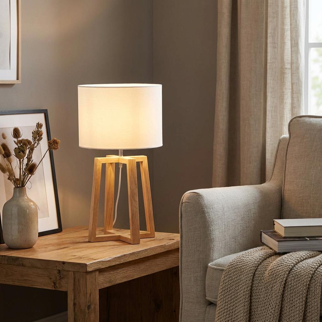 Eglo Chietino 1 rubberwood table lamp with a white drum shade lit on a wooden side table in a living room.