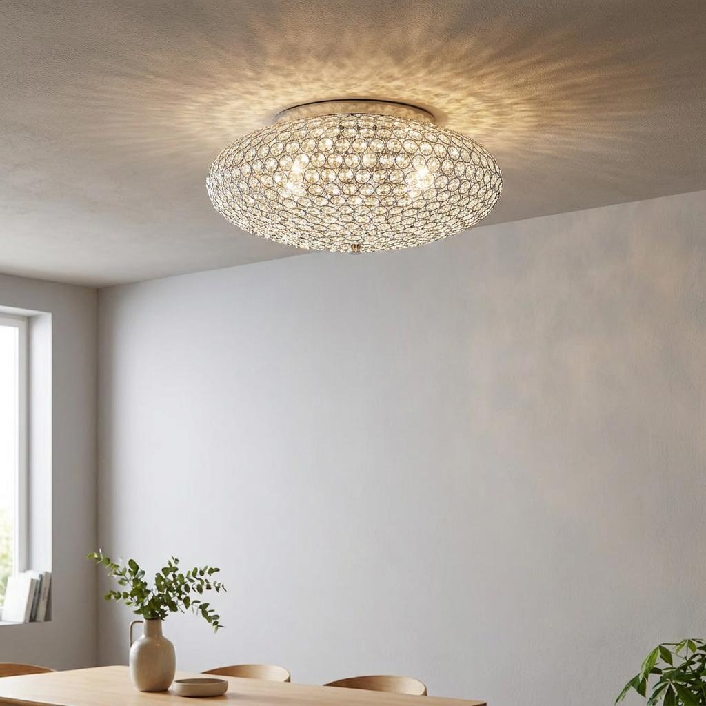 Dome-shaped chrome ceiling light with clear crystals casting a radiant pattern on a modern room ceiling.