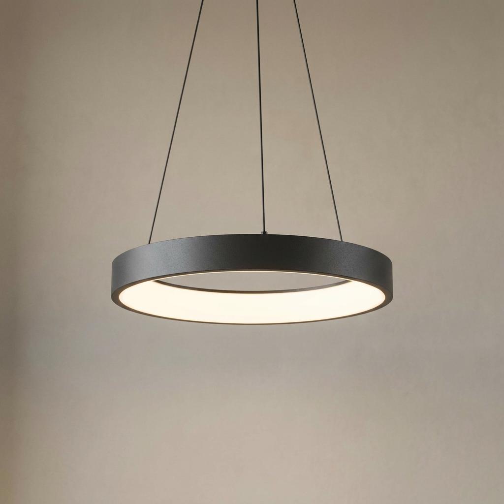 Modern black ring LED pendant light suspended by cables, featuring a warm circular glow against a plain background.
