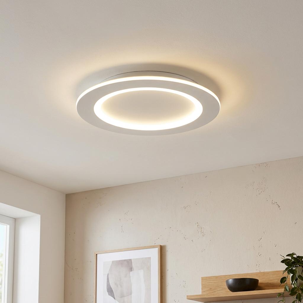 Round white LED ceiling flush light with an illuminated inner ring in a modern living room.