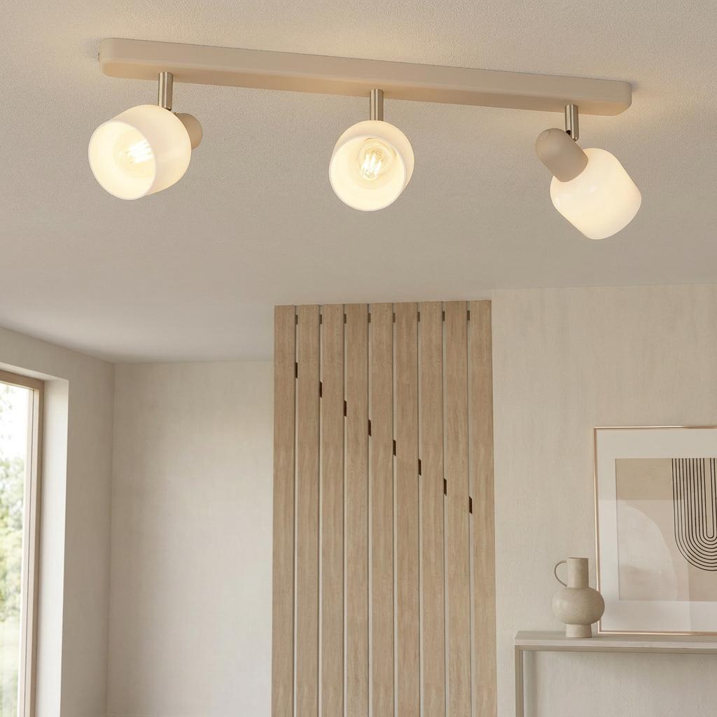 Eglo Corato 3-light sand bar spotlight with white glass shades on a ceiling in a neutral modern interior.
