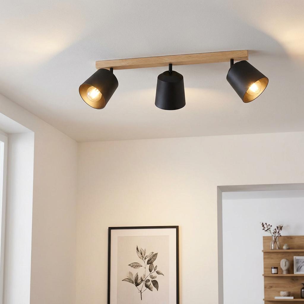 Eglo Cotorro 3 light wood and black bar spotlight mounted on a white ceiling in a modern room.