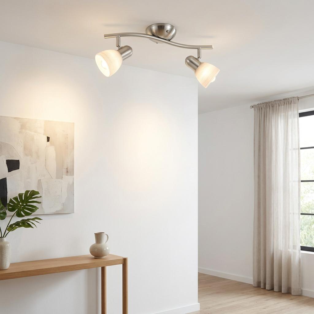 Two-light nickel bar spotlight with white glass shades mounted on a ceiling in a minimalist living room.