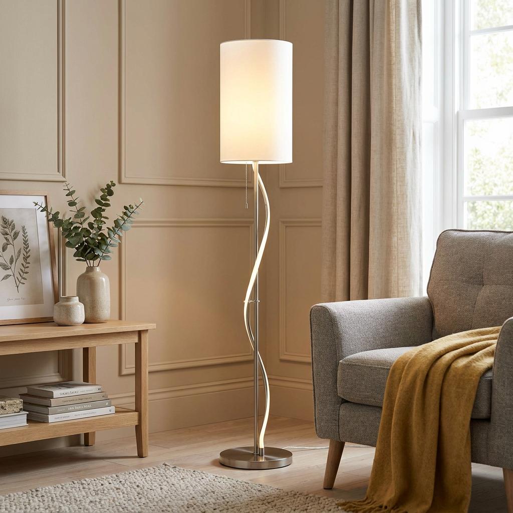 Wavy nickel floor lamp with integrated LED and a white fabric shade in a modern living room setting.
