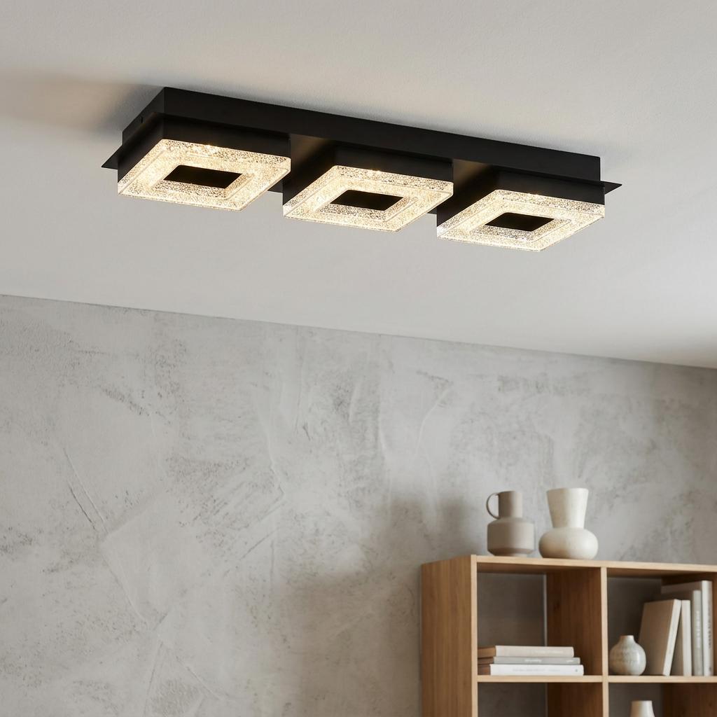Modern black flush ceiling light with three glowing square crystal frames, mounted in a contemporary room.