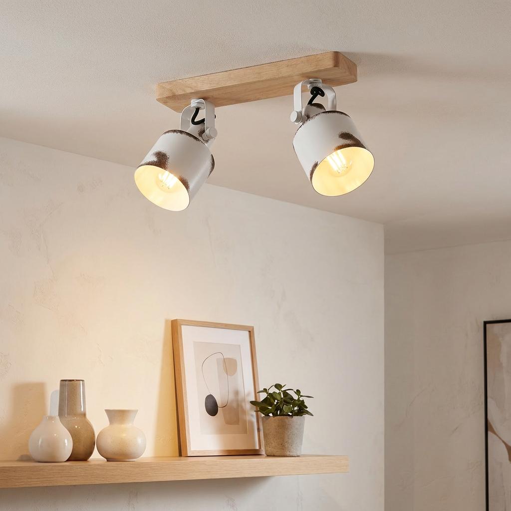 Eglo Kilburn 2-light bar spotlight with a wooden base and distressed white metal heads mounted on a ceiling.