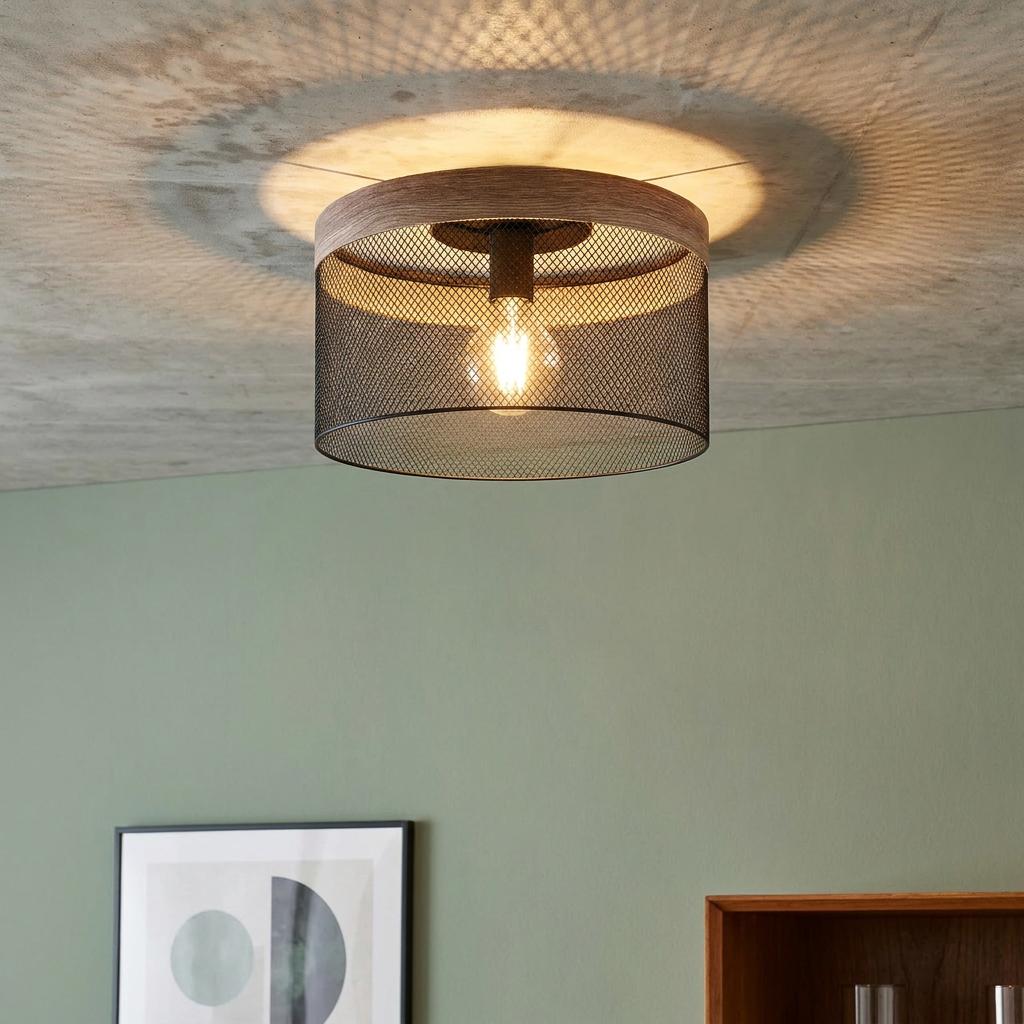 Eglo Kilnsdale flush ceiling light with wood rim and black mesh shade, illuminated against a concrete ceiling.