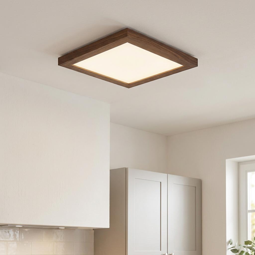 Square walnut-framed LED panel light mounted flush to a white kitchen ceiling.