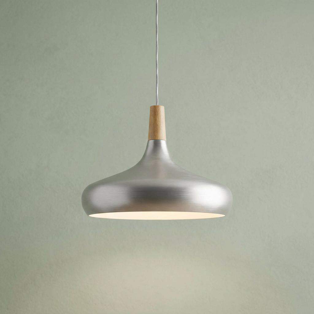 Curved silver metal and wood pendant light hanging against a textured sage green wall.